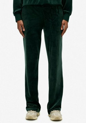 Pantaloni in velour verde scuro con una texture liscia, caratterizzati da una vestibilità comoda e un delicato logo ricamato in vita.