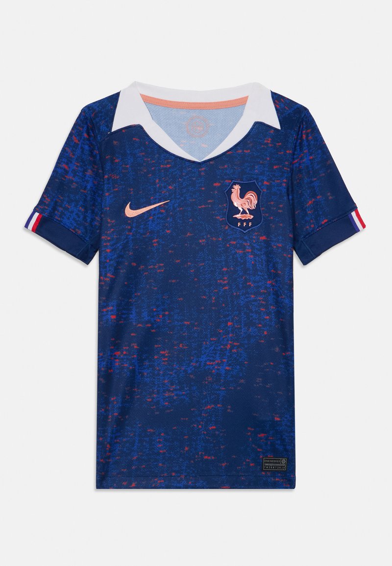 Μπλε ποδοσφαιρική φανέλα με υφή, λευκό γιακά, ροζ λεπτομέρειες, λογότυπο Nike και εθνόσημο Γαλλίας με κόκορα.