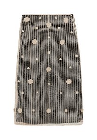 Jupe noire avec un motif en quadrillage, ornée d'appliqués floraux circulaires beiges et d'une bordure en dentelle au bas.