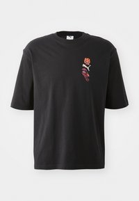 Svart bomullst-shirt med korta ärmar, rund hals och blommig grafik i orange, lila och vitt på vänster bröst.