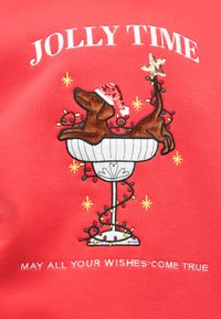 Κόκκινο φούτερ με κεντημένο σχέδιο ενός σκύλου σε μπολ με σκουφί του Άγιου Βασίλη, περιτριγυρισμένο από πολύχρωμα φώτα και κείμενο: "ΧΑΡΟΥΜΕΝΟΣ ΧΡΟΝΟΣ" και "ΜΕ ΤΟΥΣ ΑΓΙΟΥΣ ΒΑΣΙΛΗΔΕΣ ΟΛΕΣ ΣΟΥ ΟΙ ΕΥΧΕΣ ΝΑ ΓΙΝΟΥΝ ΠΡΑΓΜΑΤΙΚΟΤΗΤΑ."