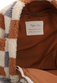 Fleece-voering tas met een geruite buitenkant in crème, roest en grijs. Binnenin is er een bruine voering en een stoffen label voor contactgegevens.