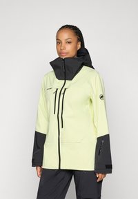 Giacca impermeabile gialla chiara e nera. Presenta un colletto alto, zip frontale e tasche con cerniera. Realizzata in materiale liscio e resistente.