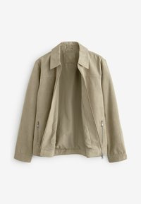 Chaqueta de ante beige con cuello puntiagudo, frente abierto y dos bolsillos laterales con cremallera. Textura suave y diseño ajustado.