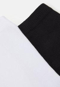 Cotton socks featuring a contrasting black and white design, with a ribbed texture and seamless transition between colors.