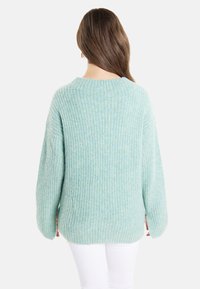Hellblau gestrickter Pullover mit lockerer Passform, geripptem Muster und überschnittenen Schultern, mit Rundhalsausschnitt und langen Ärmeln.