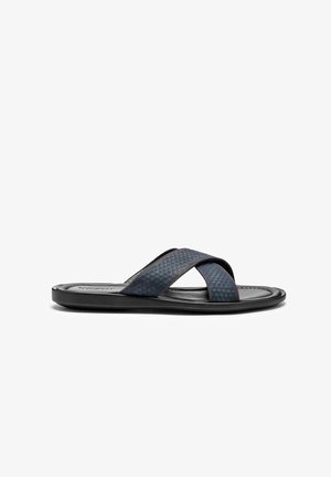 Marineblauwe slide-sandalen met een kruisbandontwerp, textuur aan de bovenkant en contrasterende rode stiksels; zwarte rubberen zool.