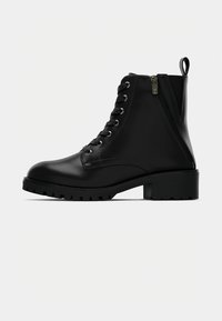 Mustad musta nahast kreenikott, millel on ümar varvas, nööbidest ees, külgsein ja tükkpõhi, millel on tekstuuriga tallad.