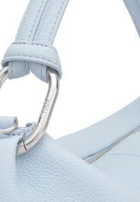 Bandoulière de sac à main en cuir texturé bleu clair fixée à un anneau en métal argenté poli gravé du mot « TOUS ».