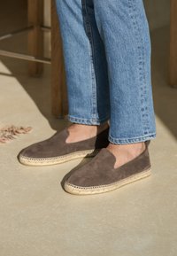 Brune ruskind espadriller med jutesåler, der har et slip-on design og en glat tekstur. Bruges med lyseblå cropped jeans.