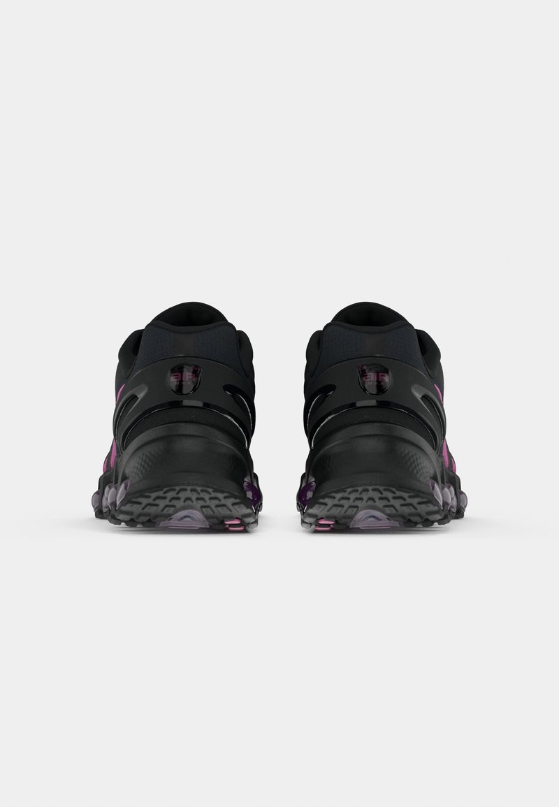 Schwarze Sportschuhe mit abgerundeter Zehenpartie, lila Akzenten, Netzpanelen und Gummisohlen mit strukturierten Griffen sowie einem flachen Design.