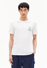 Weißes Baumwoll-T-Shirt mit kurzen Ärmeln, Rundhalsausschnitt und grünem Grafiktext "Made to make a difference" auf der linken Brust.