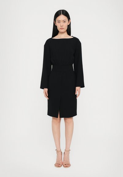 Schwarzes Kleid mit einem Bootsausschnitt, langen Ärmeln und tailliertem Bund. Verfügt über einen vorderen Schlitz und besteht aus einem glatten Stoff.