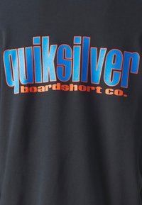 Sort t-shirt med fed blå og orange tekst. "quiksilver" er fremtrædende vist, med "boardshort co." i mindre skrifttype nedenfor.
