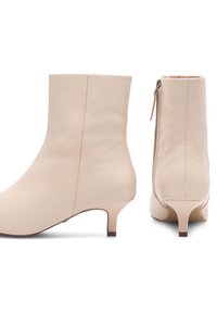 Bēša ādas potītes zābaki ar gludu tekstūru, sānu rāvējslēdzēju un 3 cm zema papēža, ar vienkāršu, minimālistisku dizainu.