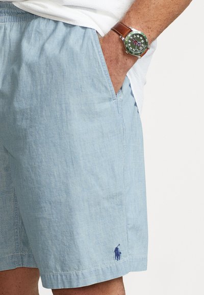 Lyseblå linnedshorts med sidelommer og et lille broderet logo. Glat tekstur med en afslappet pasform og syet kant.