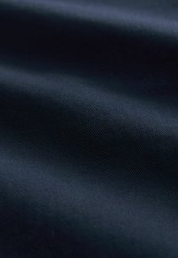 Ciemnogranatowa tkanina o gładkiej, lekko fakturowanej powierzchni z subtelnym ukośnym prążkowaniem. Lekka, o miękkim układzie.