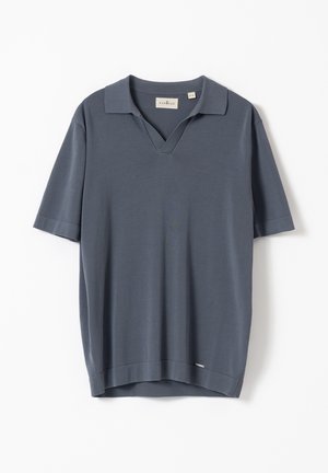 Polo de manga corta de color gris carbón con cuello abierto, tela ligera y una pequeña etiqueta de la marca cerca del dobladillo.