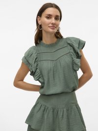 Haut texturé vert avec des manches courtes à volants et des détails de couture horizontaux, assorti d'une jupe évasée à la taille.