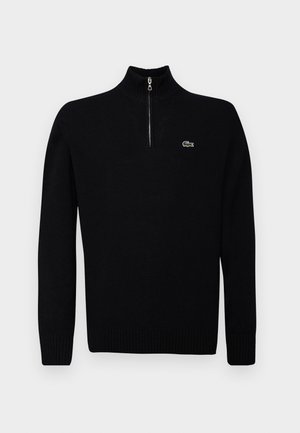 Čierny ľahký sveter s polozipovým golierom, rebrovanými manžetami a lemom, s malým zeleným logom na hrudi.