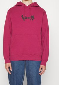 Felpa con cappuccio in magenta vivace con tasca frontale a marsupio, caratterizzata da un audace logo "Volcom" nero e polsini e orlo a coste.