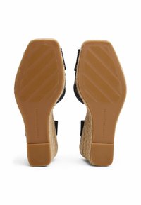 Black wedge sandals with woven jute soles, textured heels, and rubber outsoles. Features adjustable ankle straps for secure fit.