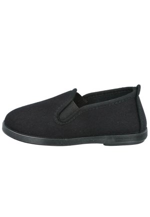 Zapato negro tipo slip-on hecho de material de lona. Presenta acentos laterales elásticos, una punta redondeada y una suela de goma texturizada.