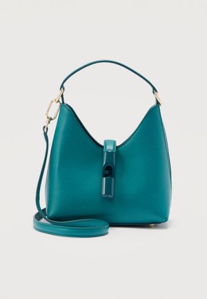 Türkisfarbene Lederhandtasche mit kurzem Griff, langem abnehmbarem Riemen und vorderem Verschlussdetail vor schlichtem hellem Hintergrund.