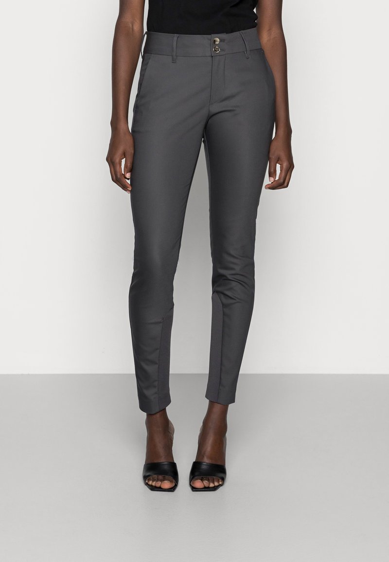 Gray fitted trousers with a smooth texture, featuring a button closure and two front pockets. Paired with black open-toe heels.