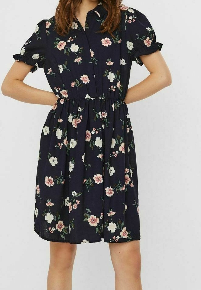 Blumenkleid aus dunkelblauem Stoff mit kurzen Puffärmeln, einer Knopfleiste vorne, einem elastischen Taillenbund und einem Muster aus rosa und weißen Blumen.