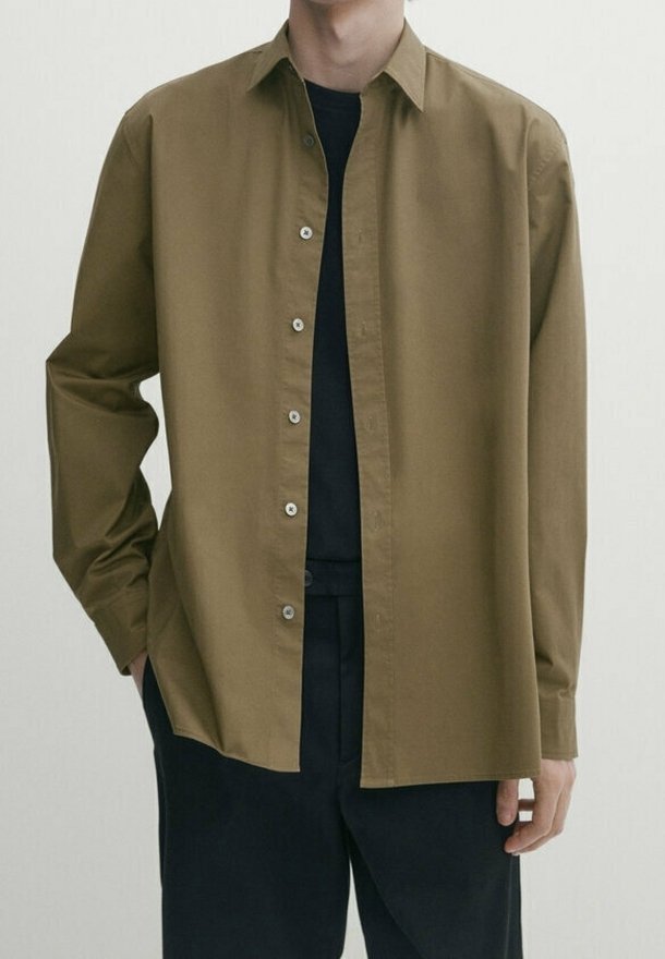 Olivgrünes Hemd mit Knopfleiste und klassischem Kragen, aus glattem Stoff gefertigt, mit lockerer Passform und versteckten Knopfdetails.