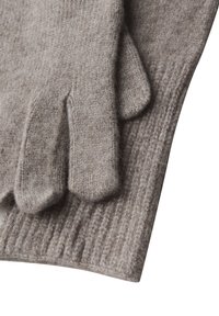 Pehmeät beige-neulotut villahanskat, joissa on ribbineulekahva, aseteltu litteäksi ja päällekkäin valkoiselle taustalle.