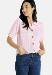 Rožu krāsas īsām piedurknēm kardigāns ar faktūrētu adījuma rakstu, ar apkakles apkakli un sešām zelta toņa pogām.