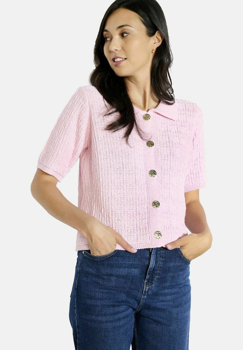 Rožu krāsas īsām piedurknēm kardigāns ar faktūrētu adījuma rakstu, ar apkakles apkakli un sešām zelta toņa pogām.