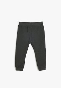 Grå ribbede sweatpants med elastisk talje og manchetter, der har to sidelommer. Glat tekstur, afslappet design der er velegnet til komfort.