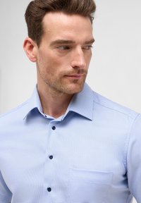  Lichtblauw bedrukte overhemde met een button-down kraag, marineblauwe knopen en een borstzak aan de linkerkant. Vriendelijke textuur en getailleerd ontwerp.
