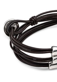 Bracelet multi-rangs en cuir marron avec accents métalliques. Présente un cuir torsadé et une fermeture argentée polie. Design texturé et moderne.