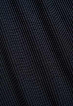 Gros plan sur un tissu côtelé noir avec des lignes texturées verticales formant un motif de nervures étroites en relief.