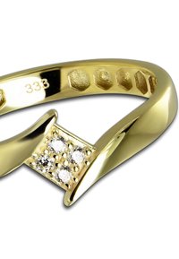 Bague en or avec un motif carré comportant quatre petits diamants ronds incrustés sur une surface texturée. Anneau lisse et poli avec une gravure intérieure.