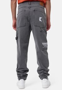 Harmaat denimhousut, joissa on useita taskuja, kapeneva istuvuus ja kirjailtu logon yksityiskohta. Varustettu teksturoidulla pinnalla ja käännettävillä lahkeilla.