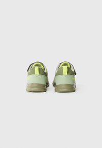 Groene sportieve schoenen met een gladde bovenkant, neongele accenten en een textuurzool. Voorzien van achterste trekriemen en een zachte binnenvoering.