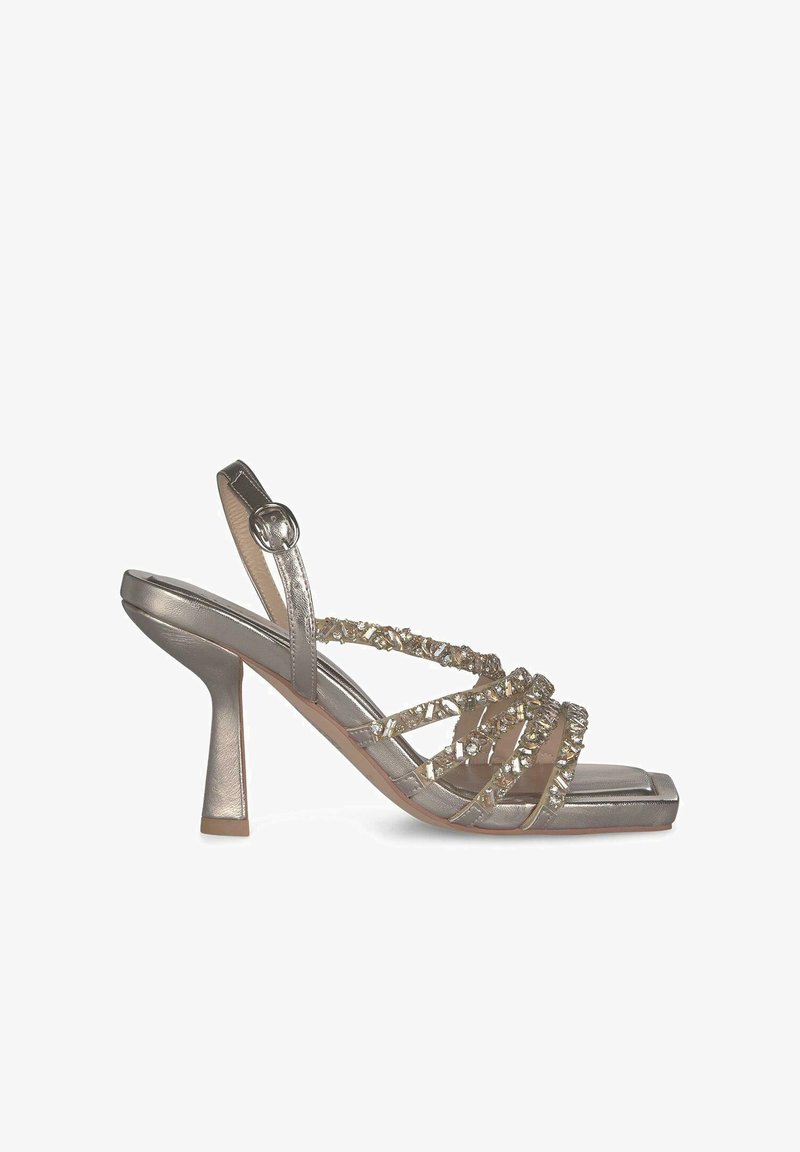 Metallic silver high-heeled sandal with translucent straps and jeweled accents. Square toe and a stiletto heel design enhance its structure.