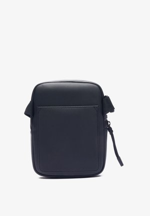 Bolsa rectangular negra hecha de material texturizado, con un bolsillo frontal, cierre de cremallera y correa ajustable. Diseño simple sin adornos.