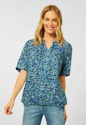Blusa corta de manga corta azul con escote en V, que presenta un colorido patrón floral abstracto en tonos verdes, negros y blancos.