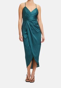 Robe en satin bleu sarcelle avec un décolleté en V, des fines bretelles et un design drapé. Présente une fente sur le côté et une longueur mi-mollet. Texture lisse et silhouette élégante.