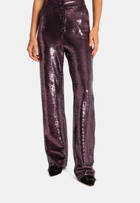Spodnie z cekinami w głębokim purpurze z rozszerzanym fasonem. Teksturowana powierzchnia odbija światło, tworząc błyszczący efekt. Wysoki stan.