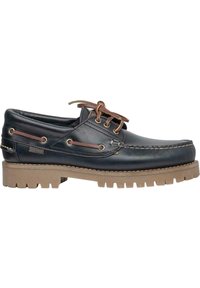 Zapatos náuticos de cuero azul marino con cordones marrones, suela de goma con un diseño de tracción grueso y costuras decorativas a lo largo del borde.