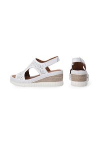 Weiße Keilsandalen mit perforiertem Design, offenen Seiten und braunen Akzenten. Verfügt über eine strukturierte Gummisohle und einen verstellbaren Fersenriemen.