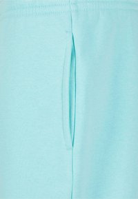 Light blue fabric featuring a side pocket. The material is soft and provides a smooth texture. Seam details are visible along the edges.