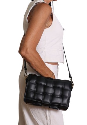 Borsa a tracolla in pelle nera con design trapuntato e tracolla regolabile, caratterizzata da una forma rettangolare e una texture liscia.